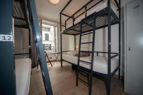 um quarto com 2 beliches e uma mesa em Enjoy Hostel em Paris