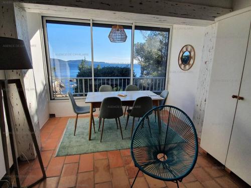 une salle à manger avec une table et des chaises et une grande fenêtre dans l'établissement Grand studio mezzanine avec vue mer, parking et climatisation à deux pas de la calanque de la Cron - FR-1-100-319, à Cavalaire-sur-Mer