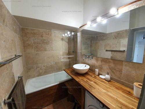 une salle de bain avec un lavabo et une baignoire dans l'établissement Grand studio mezzanine avec vue mer, parking et climatisation à deux pas de la calanque de la Cron - FR-1-100-319, à Cavalaire-sur-Mer