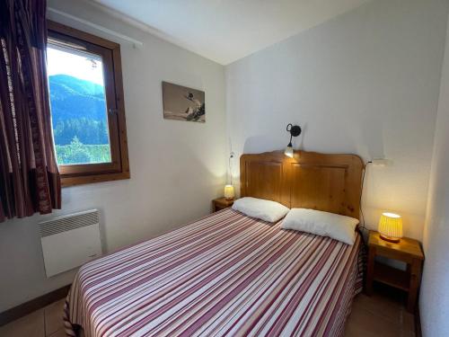 une chambre avec un lit avec deux lampes et une fenêtre dans l'établissement Appartement Calme avec Piscine, Terrasse et Skibus Proche Centre Samoëns - FR-1-624-144, à Samoëns