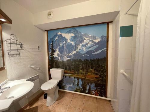 La salle de bains est pourvue d'une grande fresque murale représentant une montagne. dans l'établissement Appartement Calme avec Piscine, Terrasse et Skibus Proche Centre Samoëns - FR-1-624-144, à Samoëns