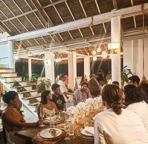 a group of people sitting around a long table at The Living Room Siargao in General Luna