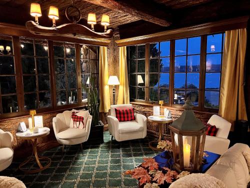 a living room with white furniture and large windows at The Latch Inn in Sidney