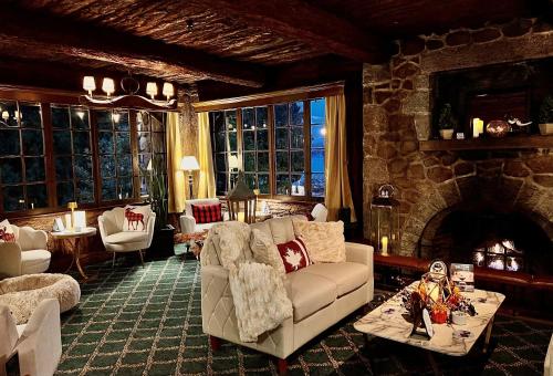 a living room with a couch and a stone fireplace at The Latch Inn in Sidney