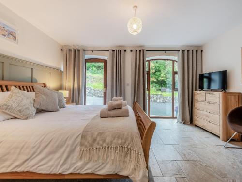 a bedroom with a large bed and a tv at Bwlchygwynt in Llanwrda