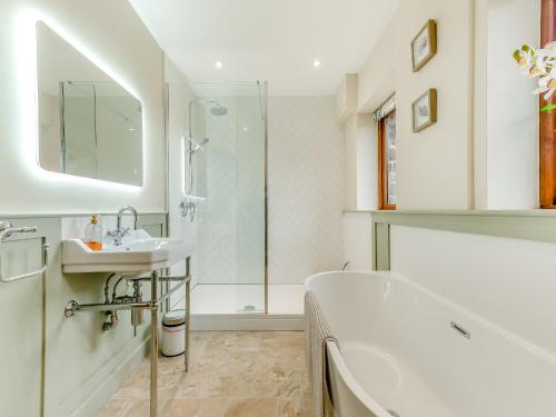 uma casa de banho com uma banheira, um lavatório e um chuveiro em Bwlchygwynt em Llanwrda