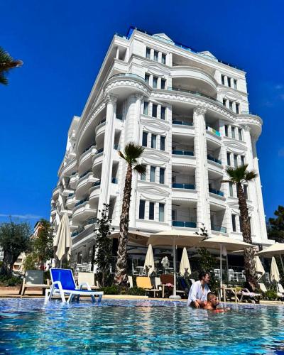 a man in a swimming pool in front of a hotel at FaFa Deluxe apartments in Golem