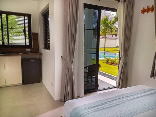 1 dormitorio con 1 cama y puerta corredera de cristal en Bungalow Khao Lak en Khao Lak