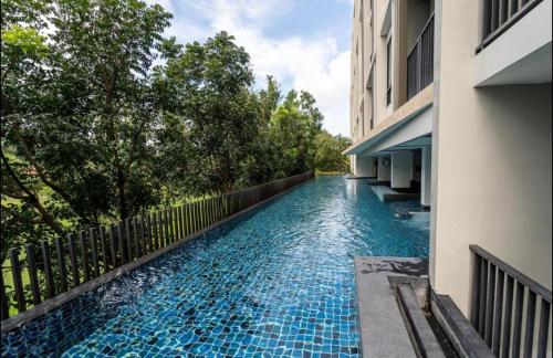 una piscina al lado de un edificio en Cozy 1 bedroom in prime Bangtao, en Bang Tao Beach