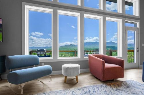 a living room with two chairs and windows at Modern Cabin near Smoky Mountain National Park in Gatlinburg