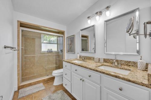 a bathroom with two sinks and a toilet and a shower at Best of Both Worlds Lakehouse in Orlando