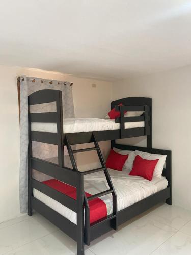 a bedroom with two bunk beds with red pillows at Bungalows Malú in Cahuita