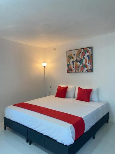 a bedroom with a large bed with red pillows at Bungalows Malú in Cahuita