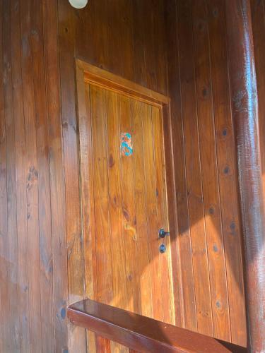 a wooden wall with a door with a sticker on it at Bungalows Malú in Cahuita