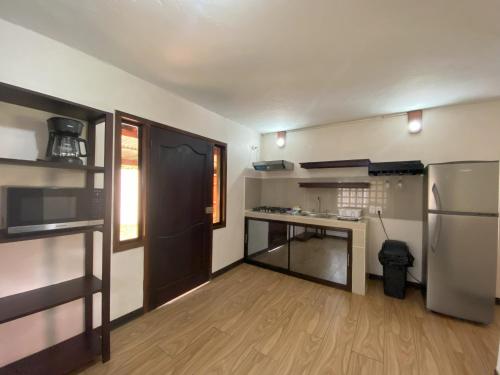 a small kitchen with a refrigerator and a counter at Bungalows Malú in Cahuita