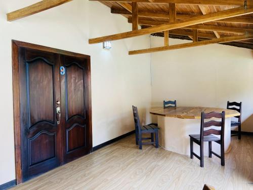 a room with a wooden door and a table and chairs at Bungalows Malú in Cahuita