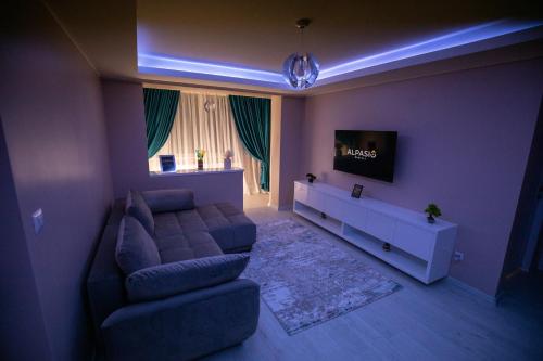 uma sala de estar com um sofá e uma televisão em Alpasio Rentals 2 em Galaţi