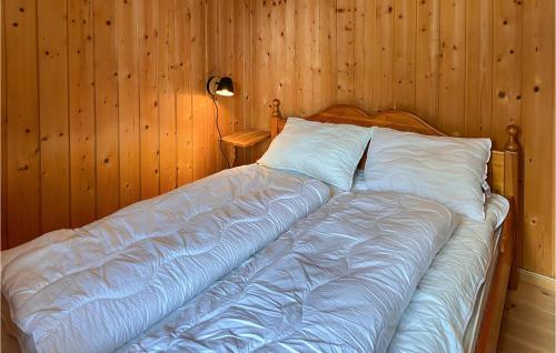 a bed in a room with a wooden wall at 3 Bedroom Nice Home In Bjorli in Bjorli