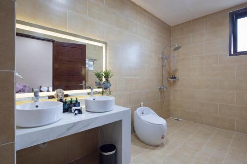 a bathroom with two sinks and a shower at Four Spring Villas & Golfs Da Lat in Da Lat