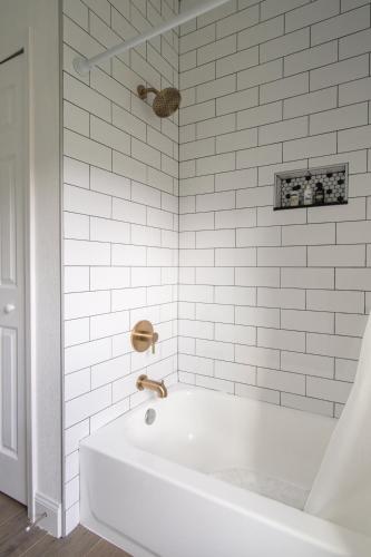 a white bath tub with a gold faucet in a bathroom at Florida Luxe, Brand new 4 Bed Property with a Private Jacuzzi in Tampa