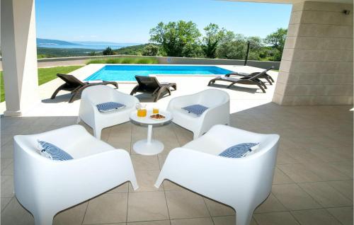 a patio with white chairs and a table and a pool at Villa Histria in Pula