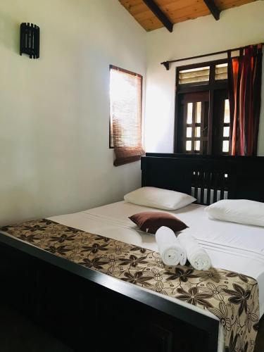 a bedroom with two beds with towels on them at Ganesh Garden Beach Cabanas in Tangalle