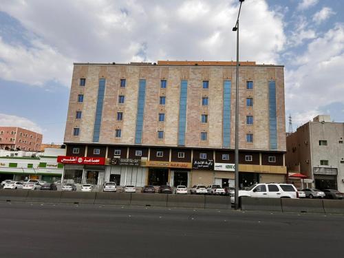 a large building with cars parked in a parking lot at ليالي الراحة للوحدات السكنية in Taif