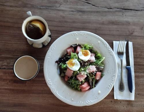 a bowl of food with eggs on a table with a cup of coffee at BB Garden Resort in Canggu
