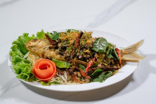 a plate of food with a salad with a fish on it at Bouasavan Hotel and Garden in Savannakhet