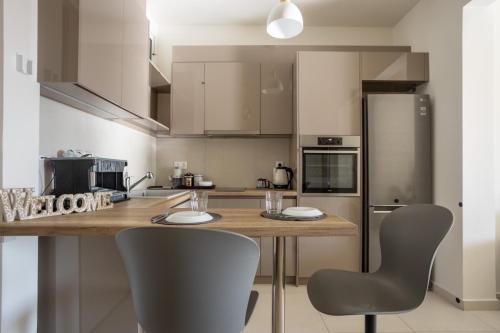 a kitchen with a wooden table and two chairs at AIOLOS GLYFADA luxury sea view suite 5 in Athens