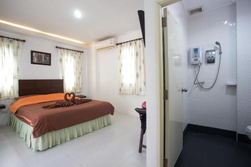 um quarto com uma cama e um chuveiro e uma casa de banho em Treeside Guest House Resort em Ban Thung Chao