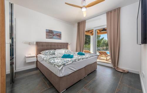 1 dormitorio con 1 cama y ventilador de techo en Lovely Home In Pasman With Kitchen, en Pašman
