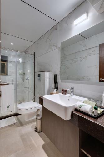 a bathroom with a sink and a shower and a toilet at The Fern Sardar Sarovar Resort Kevadia, Gujarat in Kevadia