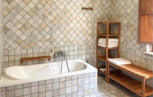 baño con bañera y pared de azulejos en La Casa Nel Bosco, en San Massimo
