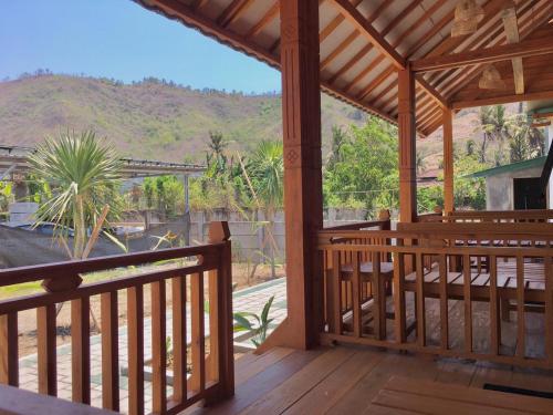 a wooden porch with a view of a mountain at Mandalika Queen Hostel in Kuta Lombok