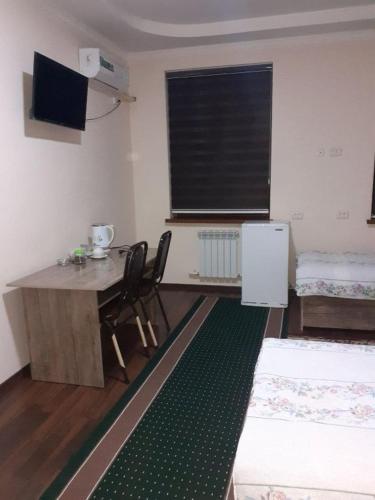 a room with a table and chairs and a window at HOTEL ABU BAKIR in Denov