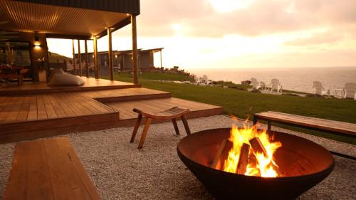 a fire pit with a bench and a table at The Cove Tasmania in Devonport