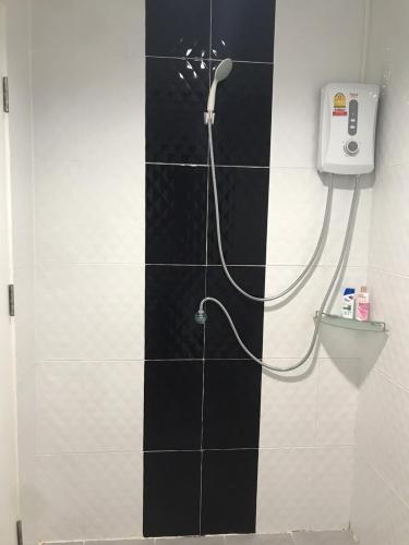 e bagno con doccia e parete piastrellata in bianco e nero. di Rest Mind House a Ban Lum Fuang