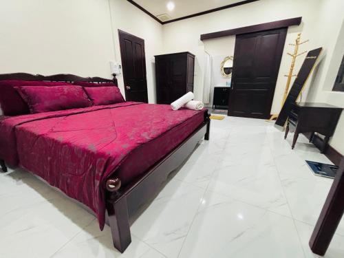 a bedroom with a bed with a red comforter at Mano Residence esidence in Luang Prabang