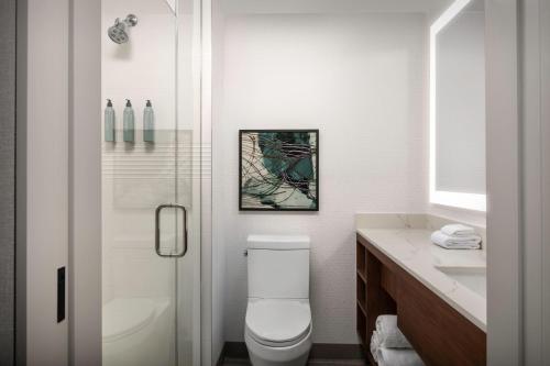 a white bathroom with a toilet and a shower at Residence Inn by Marriott New York Queens in Queens