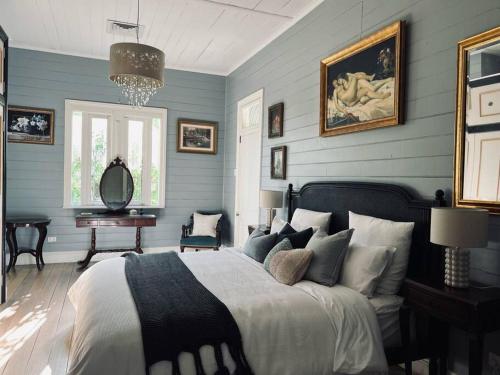 a bedroom with blue walls and a large bed at Byron Homestead in Ewingsdale