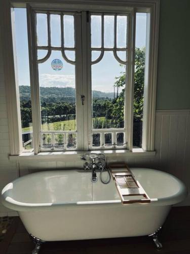 a white bath tub in front of a window at Byron Homestead in Ewingsdale
