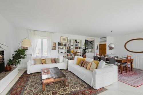 Easylife - Attico 230mq con terrazza area Bocconi في ميلانو: غرفة معيشة مع كنبتين بيضاء وطاولة