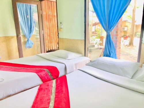 2 camas en una habitación con ventana en The Relax Resort, en Ko Pha Ngan