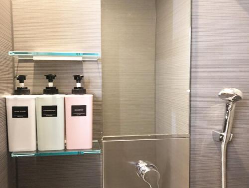 baño con ducha y 3 botellas en la pared en LIFT IN HAKUBA GORYU - Vacation STAY 71289v en Iida