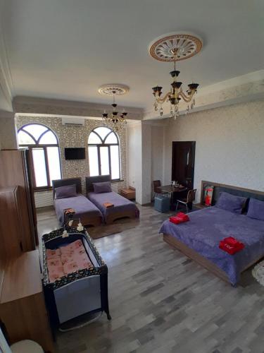 Habitación grande con 2 camas y sofá en Delfin Guest House, en Ganja
