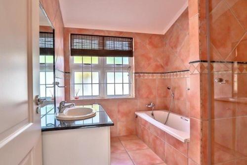 a bathroom with a sink and a bath tub at Apartments Hout Bay in Cape Town