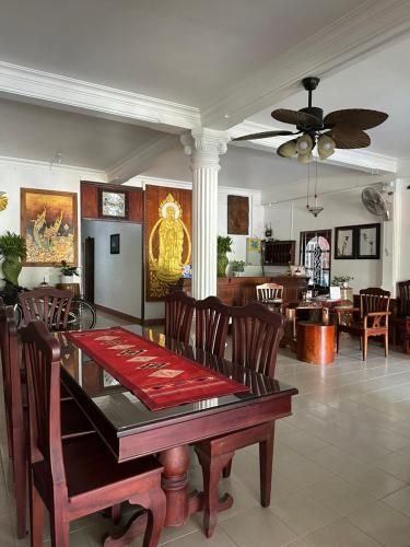 a dining room with a table and chairs and a living room at Mano boutique sun shine in Luang Prabang