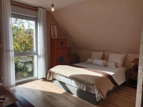 ein Schlafzimmer mit einem Bett und einem großen Fenster in der Unterkunft Villa des Climats Bourgogne in Marsannay-la-Côte