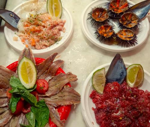 quattro piatti di cibo su un tavolo con cibo di Fikus APT relax Castello Ursino a Catania